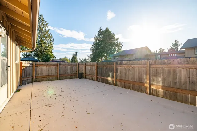a view of backyard with wooden fence