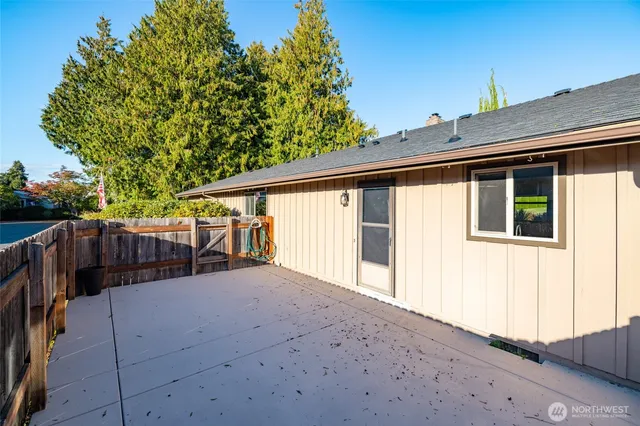 a view of backyard with green space and wooden fence