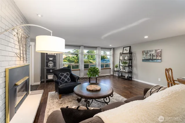 a living room with furniture a fireplace and a large window