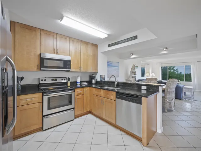 a kitchen with stainless steel appliances granite countertop a stove top oven a sink dishwasher and white cabinets