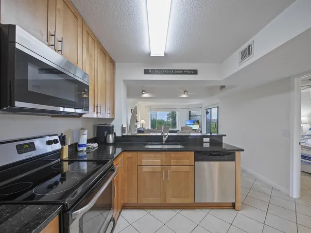 a kitchen with stainless steel appliances a sink dishwasher stove top oven and cabinets