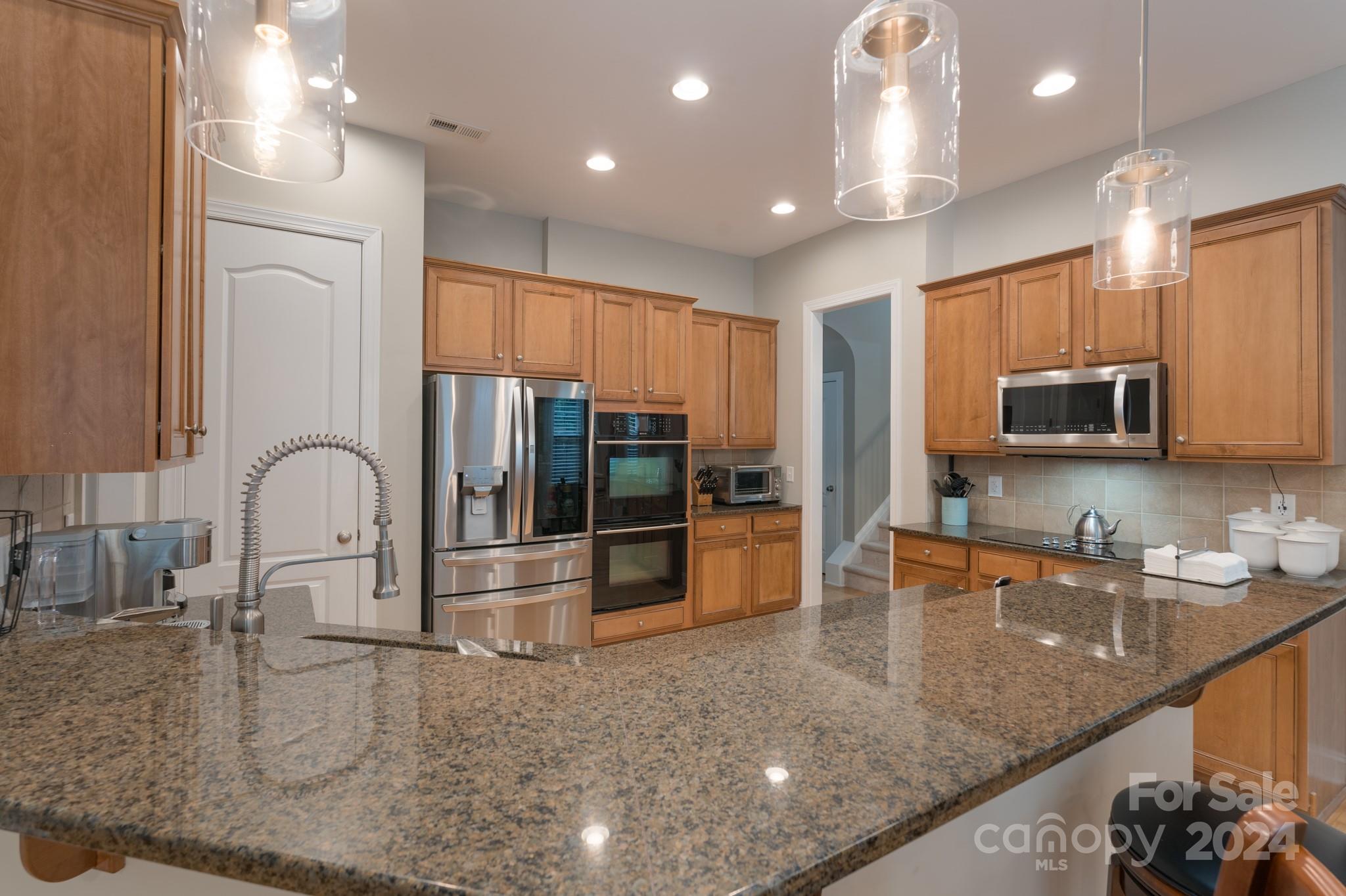 925 Treasure Court Fort Mill, SC 29708 - Photo 17 of 45 a kitchen with stainless steel appliances granite countertop a sink a stove and a microwave with granite countertop