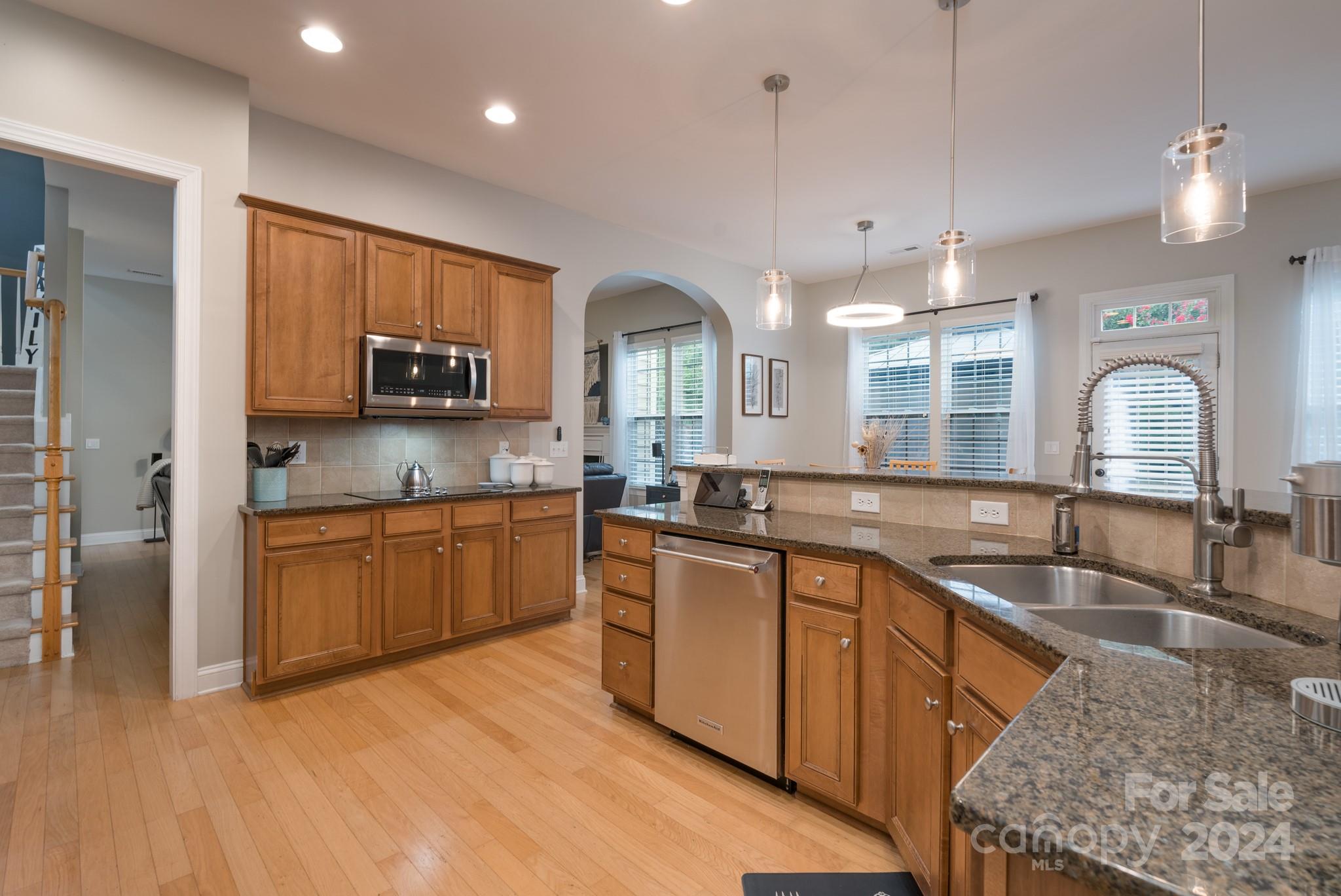 925 Treasure Court Fort Mill, SC 29708 - Photo 19 of 45 a kitchen with stainless steel appliances granite countertop a sink a stove and a wooden cabinets