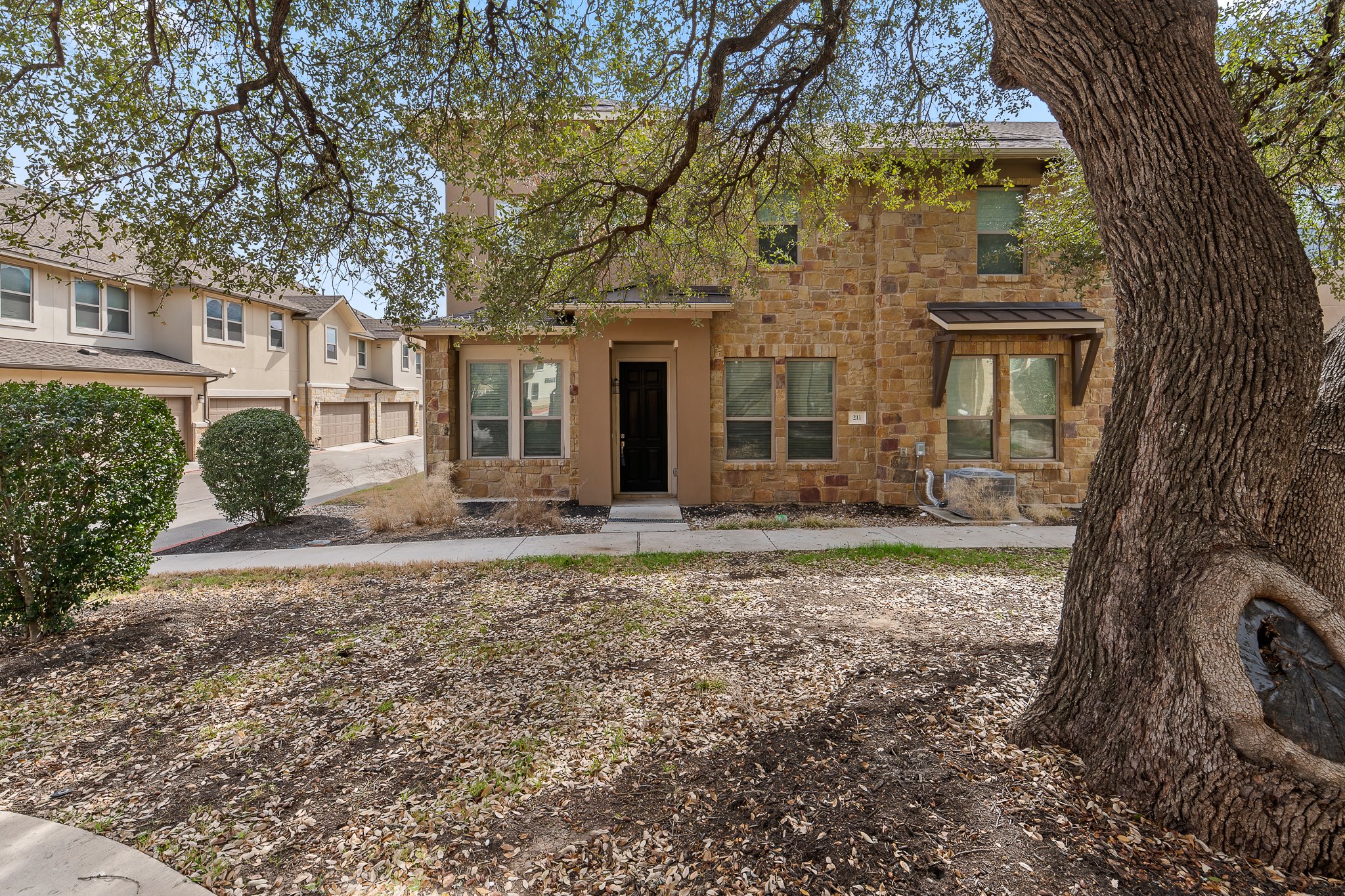 13800 Lyndhurst Street, Unit 211 Austin, TX 78717 - Photo 1 of 40 View of front of property with stone siding, stucco, and a sidewalk