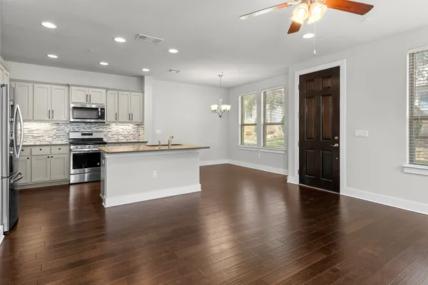 a view of kitchen with refrigerator stove and wooden floor