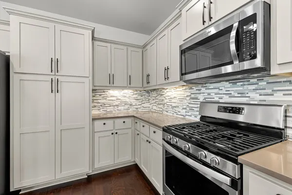 a view of kitchen with granite countertop stainless steel appliances refrigerator sink and cabinets