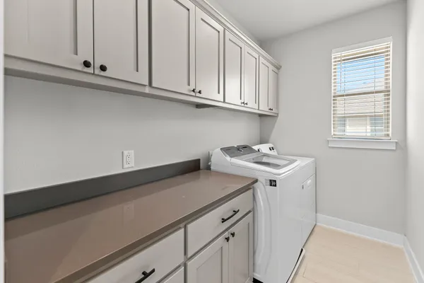 an empty room with windows and chandelier fan