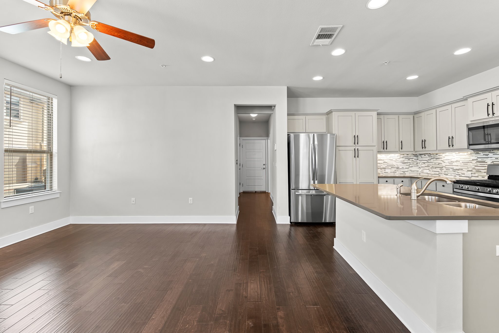 13800 Lyndhurst Street, Unit 211 Austin, TX 78717 - Photo 3 of 40 Kitchen featuring stainless steel appliances, dark wood-style flooring, recessed lighting, and tasteful backsplash