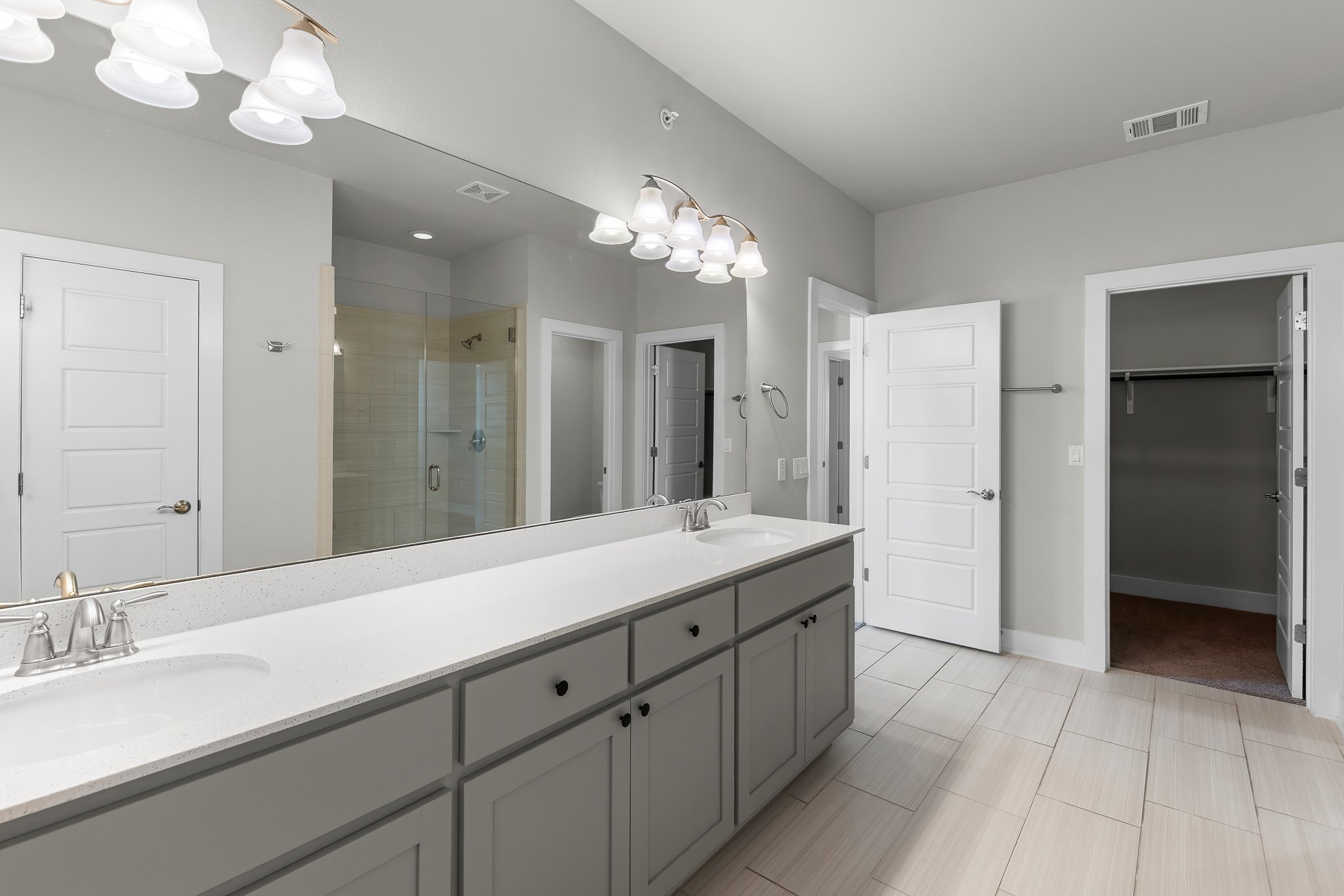 13800 Lyndhurst Street, Unit 211 Austin, TX 78717 - Photo 35 of 40 Bathroom with double vanity, a stall shower, suspended lighting, and a walk in closet