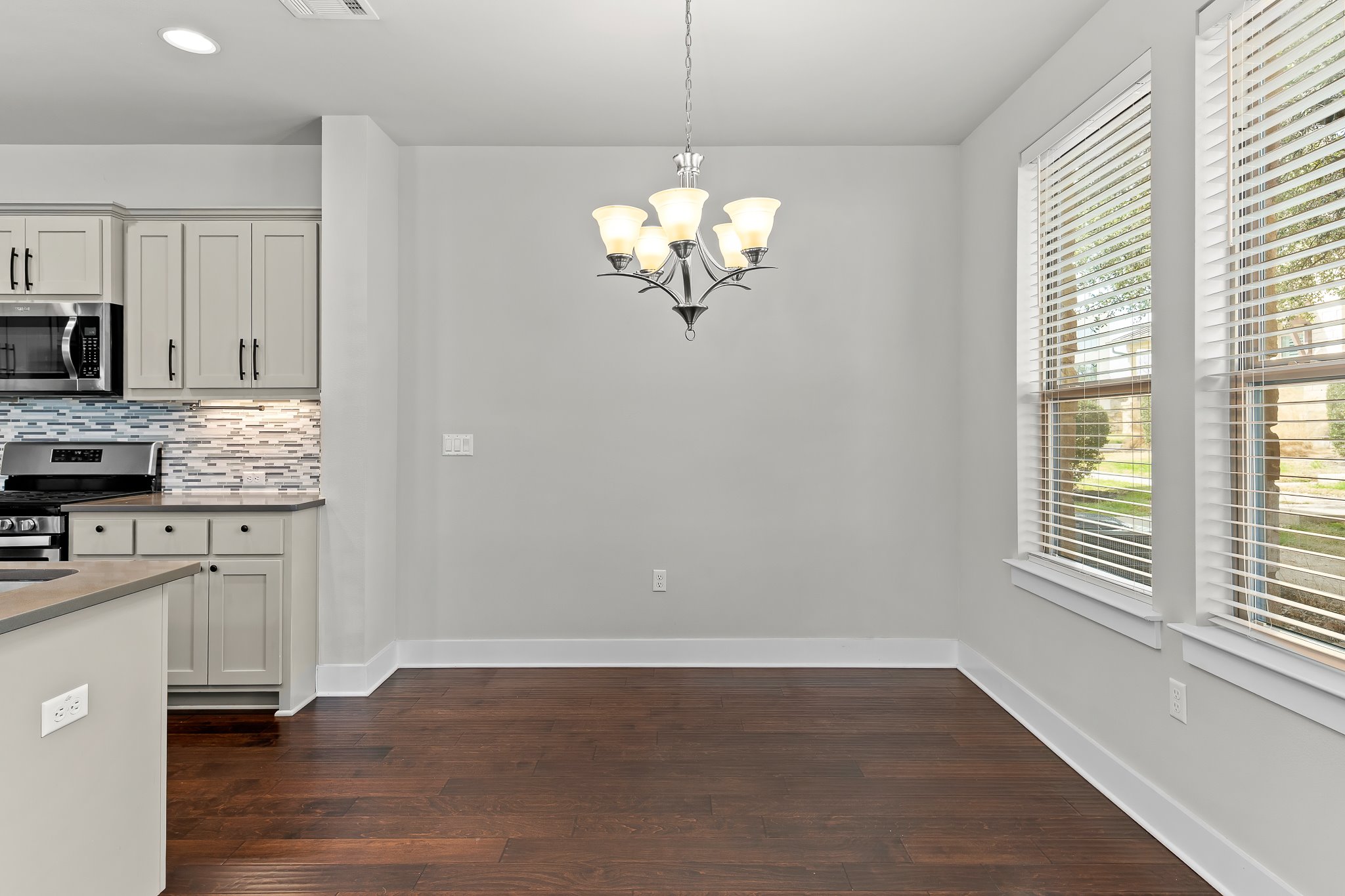 13800 Lyndhurst Street, Unit 211 Austin, TX 78717 - Photo 9 of 40 Kitchen featuring stainless steel appliances, dark wood-type flooring, backsplash, and a chandelier