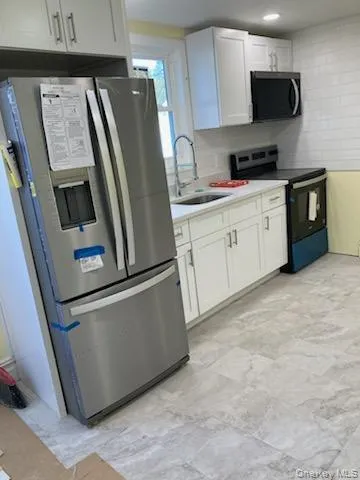a kitchen with stainless steel appliances a refrigerator sink and microwave