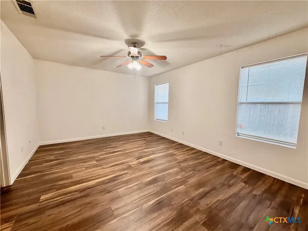 wooden floor in an empty room with a window