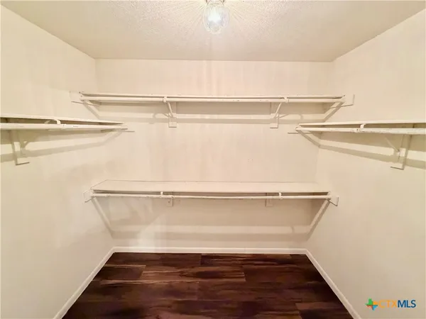 a view of walk in closet with empty racks