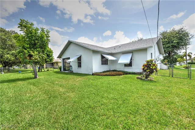 a backyard of a house with table and chairs