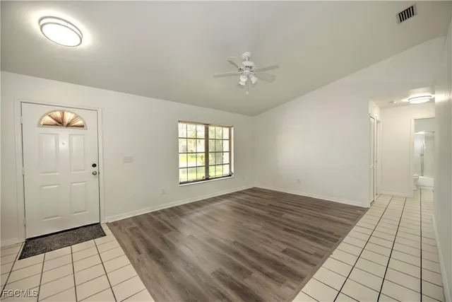 a view of an empty room and window chandelier fan