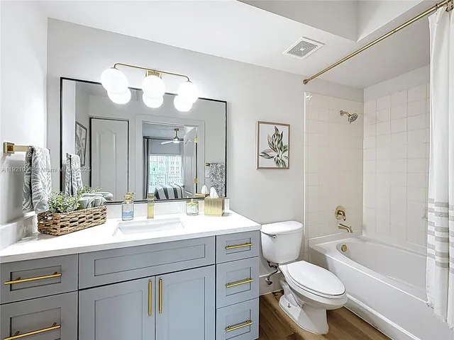 a bathroom with a toilet a sink and a large mirror