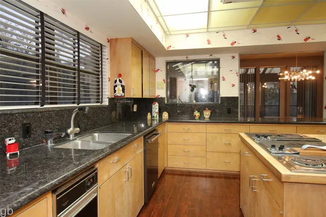 a kitchen with stainless steel appliances granite countertop a sink stove and cabinets