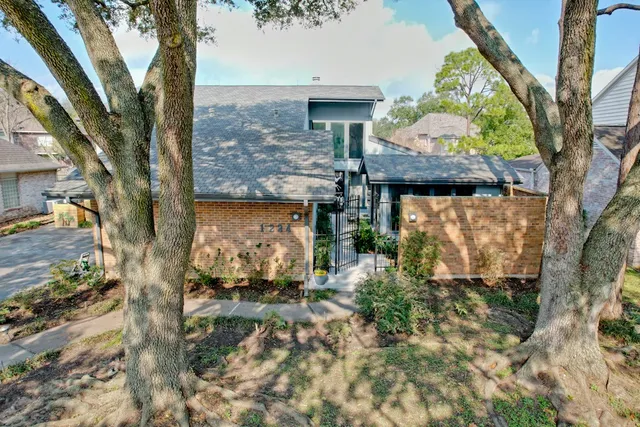 a view of a brick house with a large tree