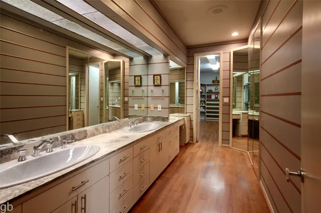 a large kitchen with a sink and wooden floor
