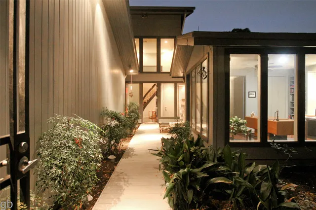 a view of a porch with chairs and floor to ceiling window