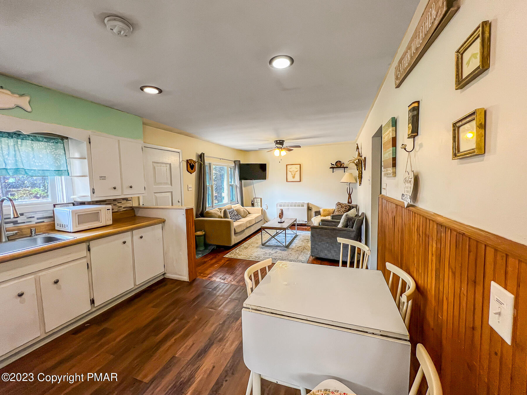 216 Sutton Place Pocono Summit, PA 18346 - Photo 6 of 34 a living room with couches and kitchen view with wooden floor