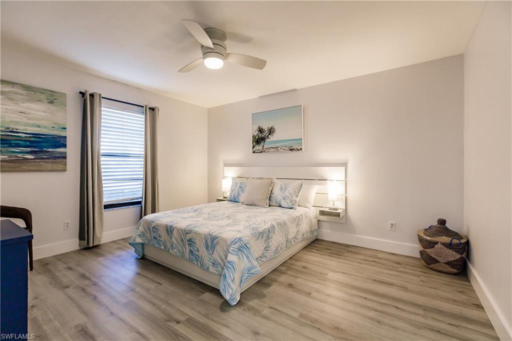 600 Neapolitan Way, Unit 152 Naples, FL 34103 - Photo 14 of 41 a bedroom with a bed and wooden floor