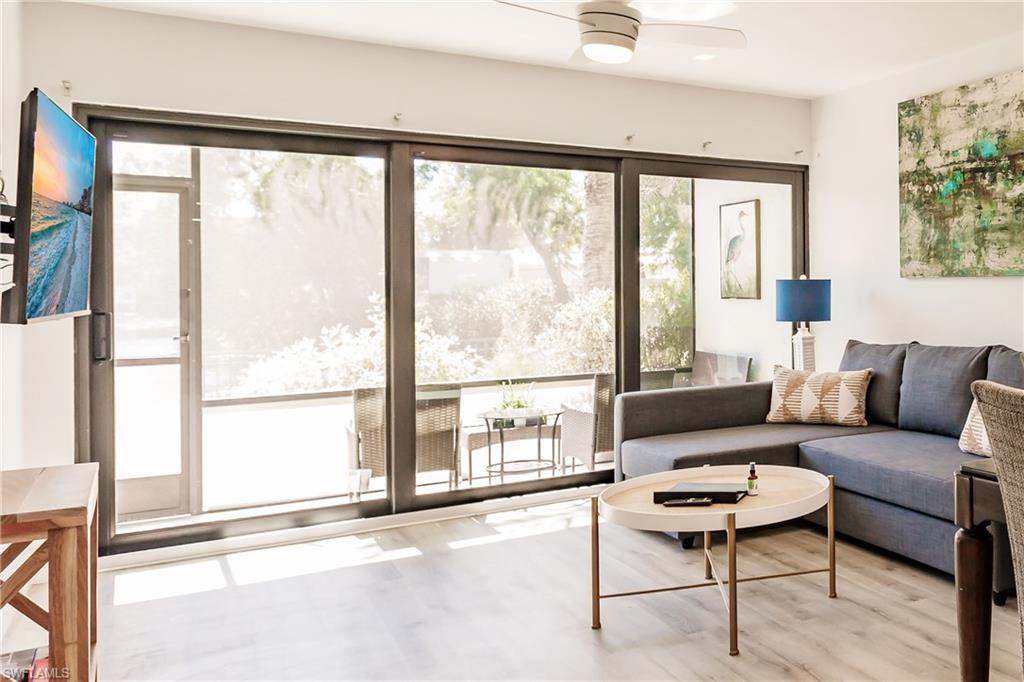 600 Neapolitan Way, Unit 152 Naples, FL 34103 - Photo 2 of 41 a living room with furniture and a large window