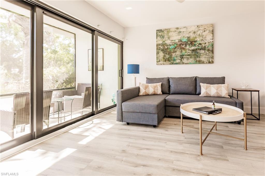 600 Neapolitan Way, Unit 152 Naples, FL 34103 - Photo 4 of 41 a living room with furniture and a large window