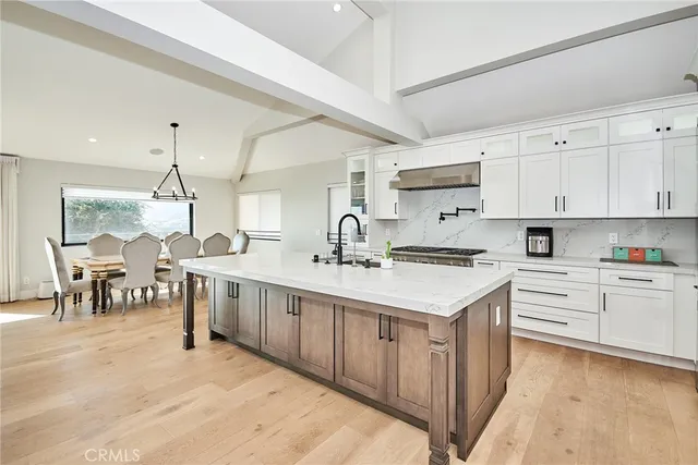 a kitchen with stainless steel appliances granite countertop a stove and white cabinets