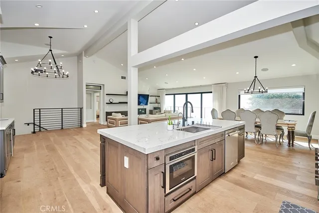 a kitchen with kitchen island a sink appliances and a counter top space