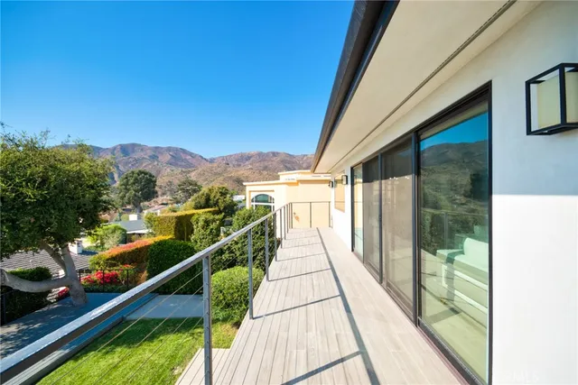 a view of a balcony with wooden floor and fence