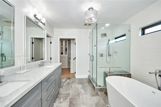 a en suite bathroom with a granite countertop sink and a mirror