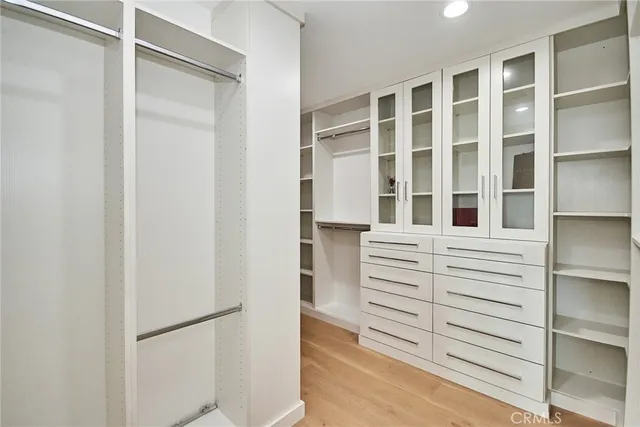a view of a hallway with wooden floor and a living room