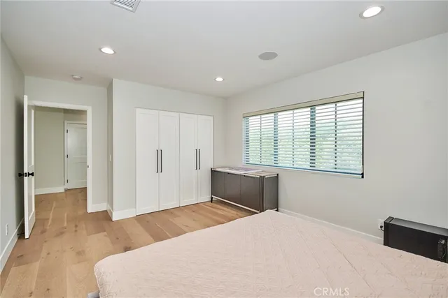 a bedroom with a bed and a large window