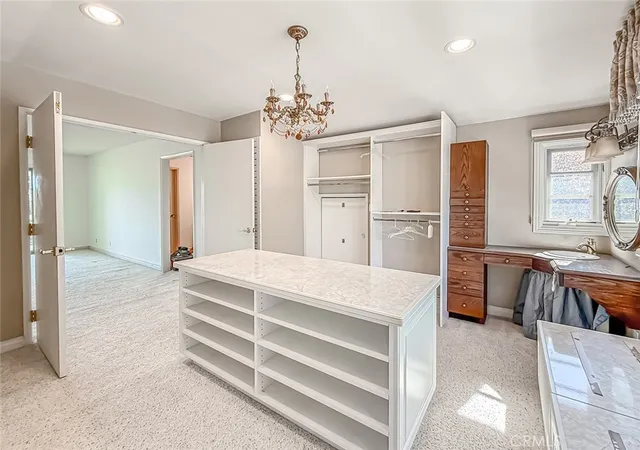 a spacious bedroom with a bed and a chandelier