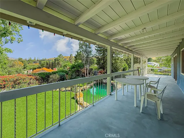 a view of two chairs and table in the balcony