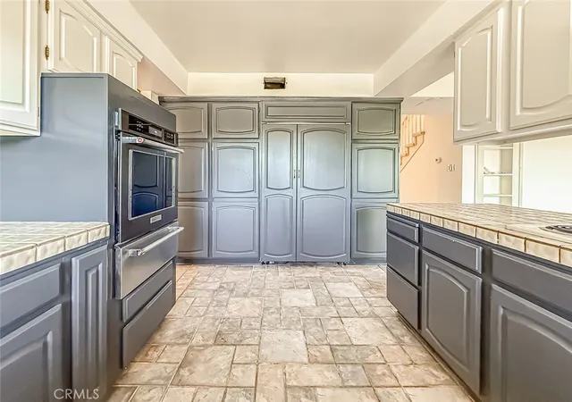 a kitchen with granite countertop a refrigerator and a stove top oven
