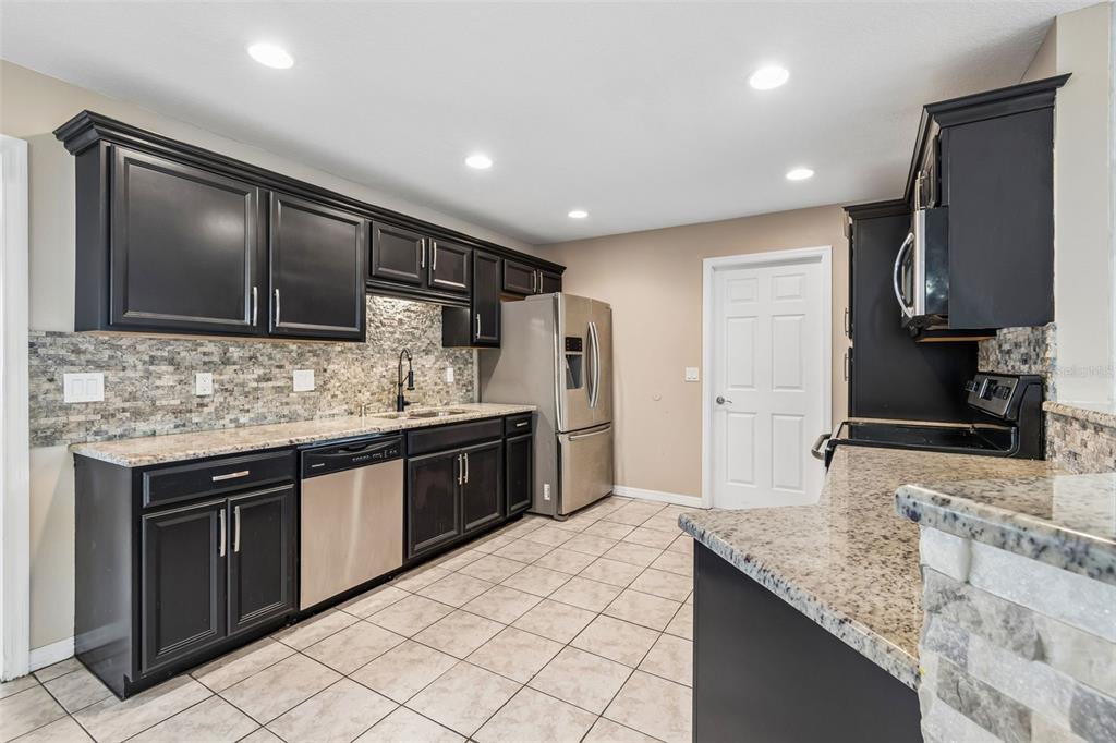 4018 Prado Drive Sarasota, FL 34235 - Photo 18 of 74 a kitchen with stainless steel appliances granite countertop a sink stove and refrigerator