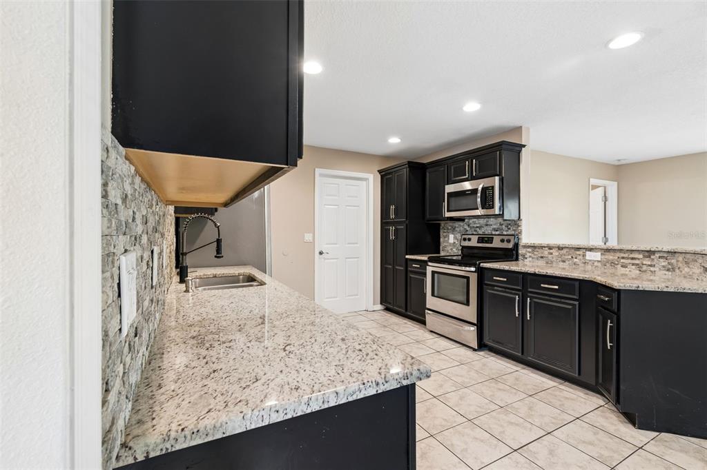4018 Prado Drive Sarasota, FL 34235 - Photo 20 of 74 a kitchen with stainless steel appliances granite countertop refrigerator sink and stove