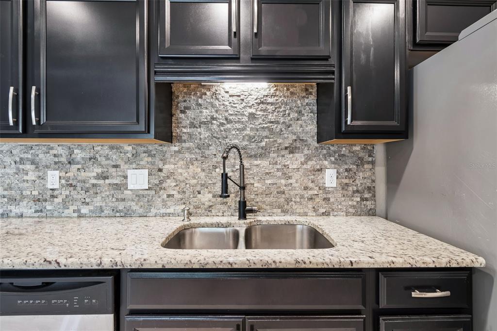 4018 Prado Drive Sarasota, FL 34235 - Photo 21 of 74 a kitchen with granite countertop a sink and cabinets
