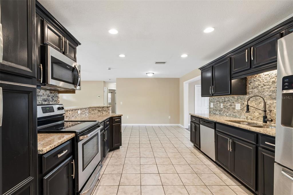 4018 Prado Drive Sarasota, FL 34235 - Photo 24 of 74 a kitchen with stainless steel appliances granite countertop a stove and a sink
