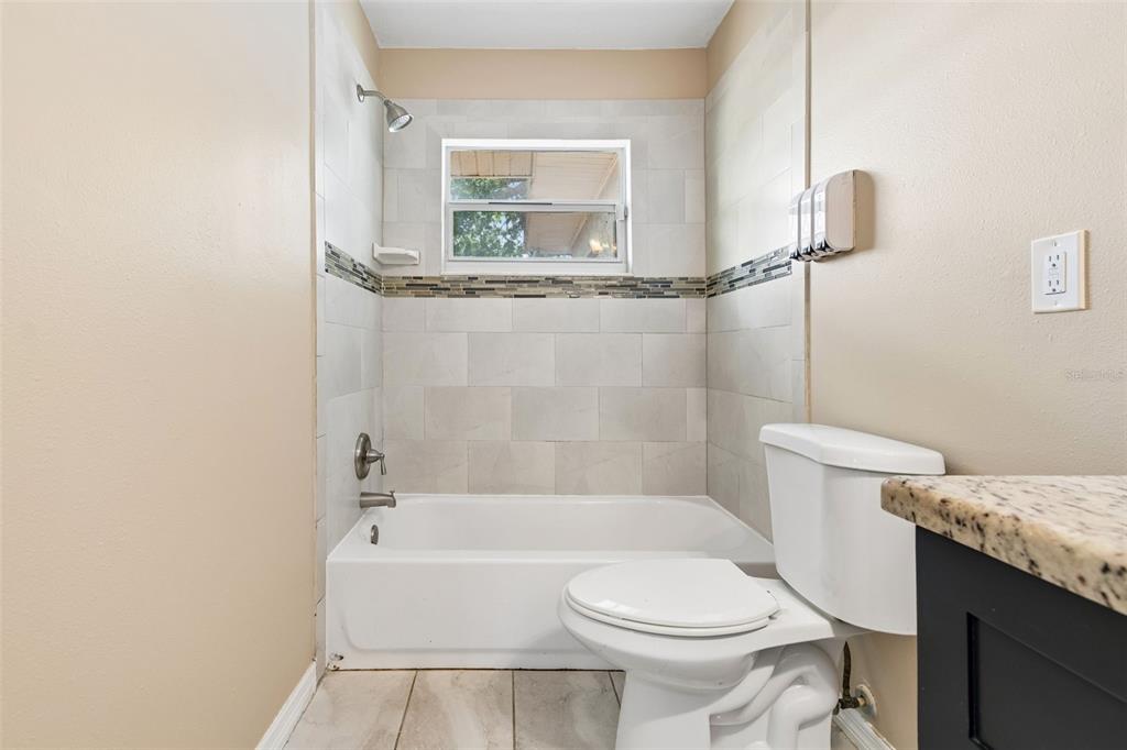 4018 Prado Drive Sarasota, FL 34235 - Photo 48 of 74 a bathroom with a granite countertop toilet sink and mirror