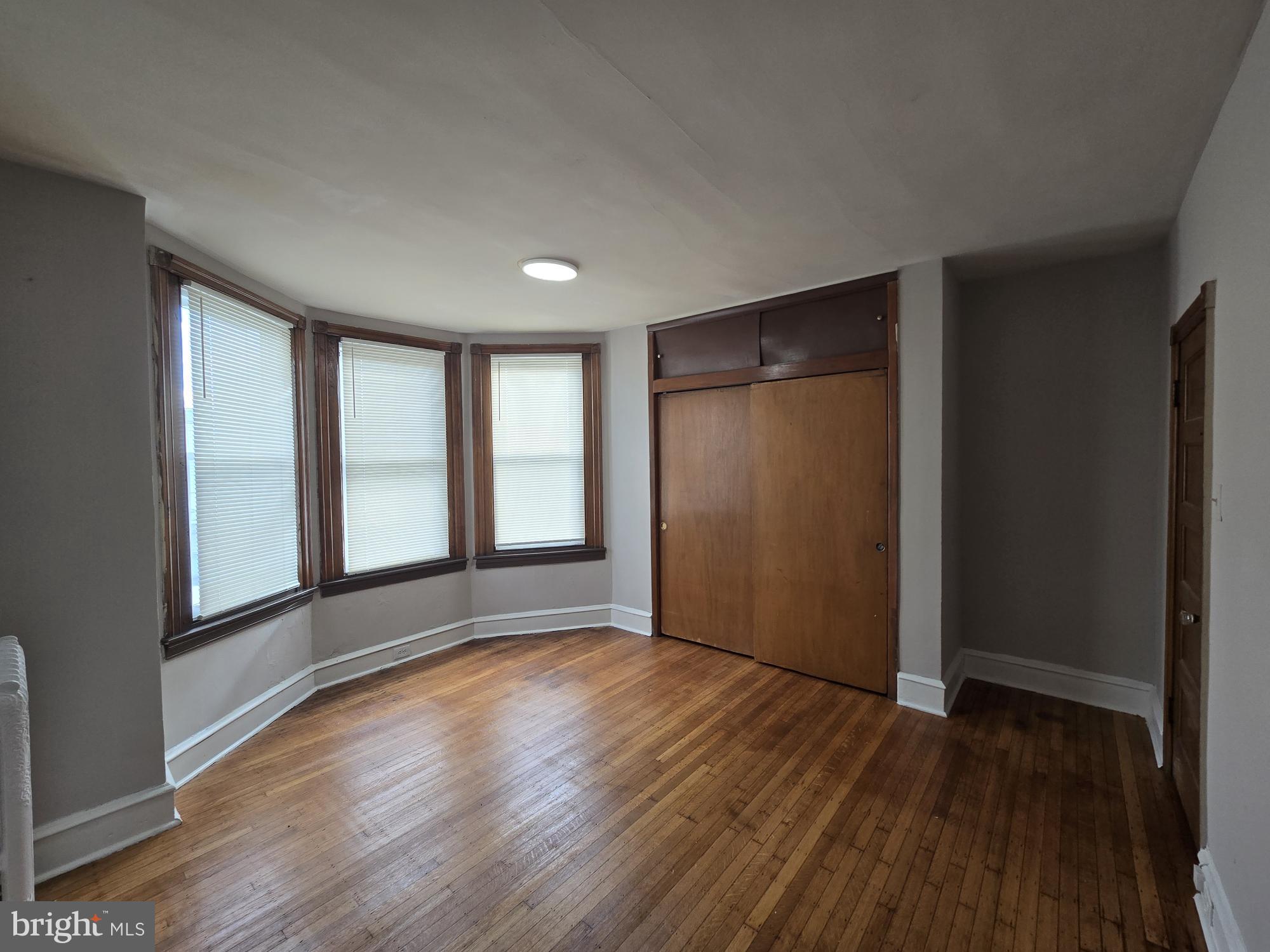 4254 North 7th Street Philadelphia, PA 19140 - Photo 15 of 26 an empty room with wooden floor and windows