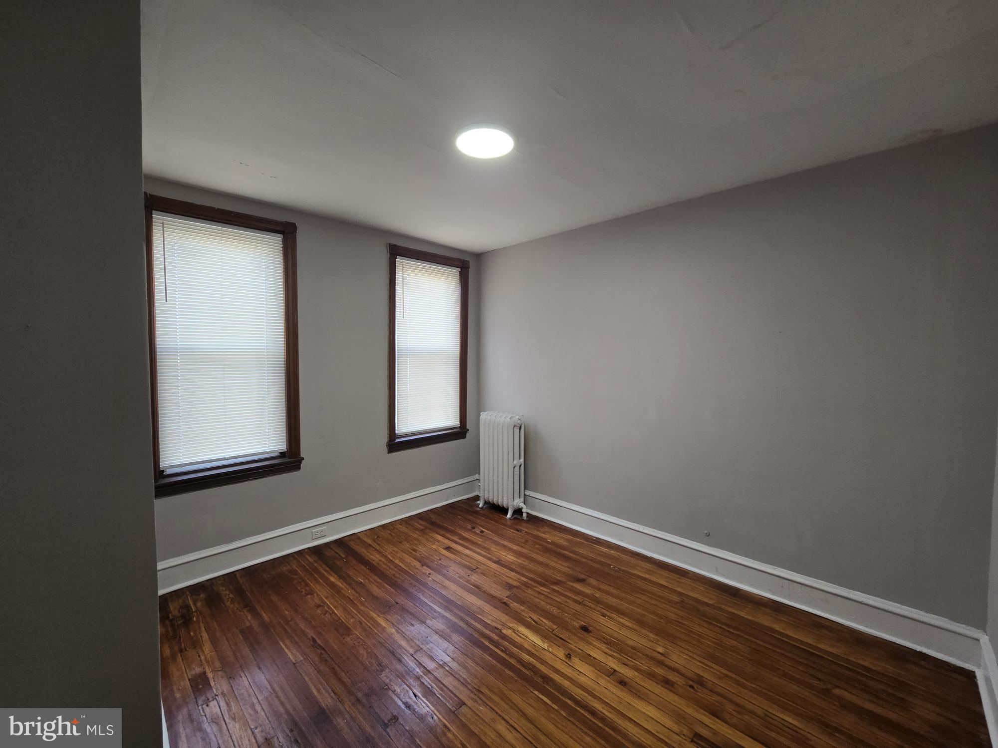 4254 North 7th Street Philadelphia, PA 19140 - Photo 18 of 26 an empty room with wooden floor and windows