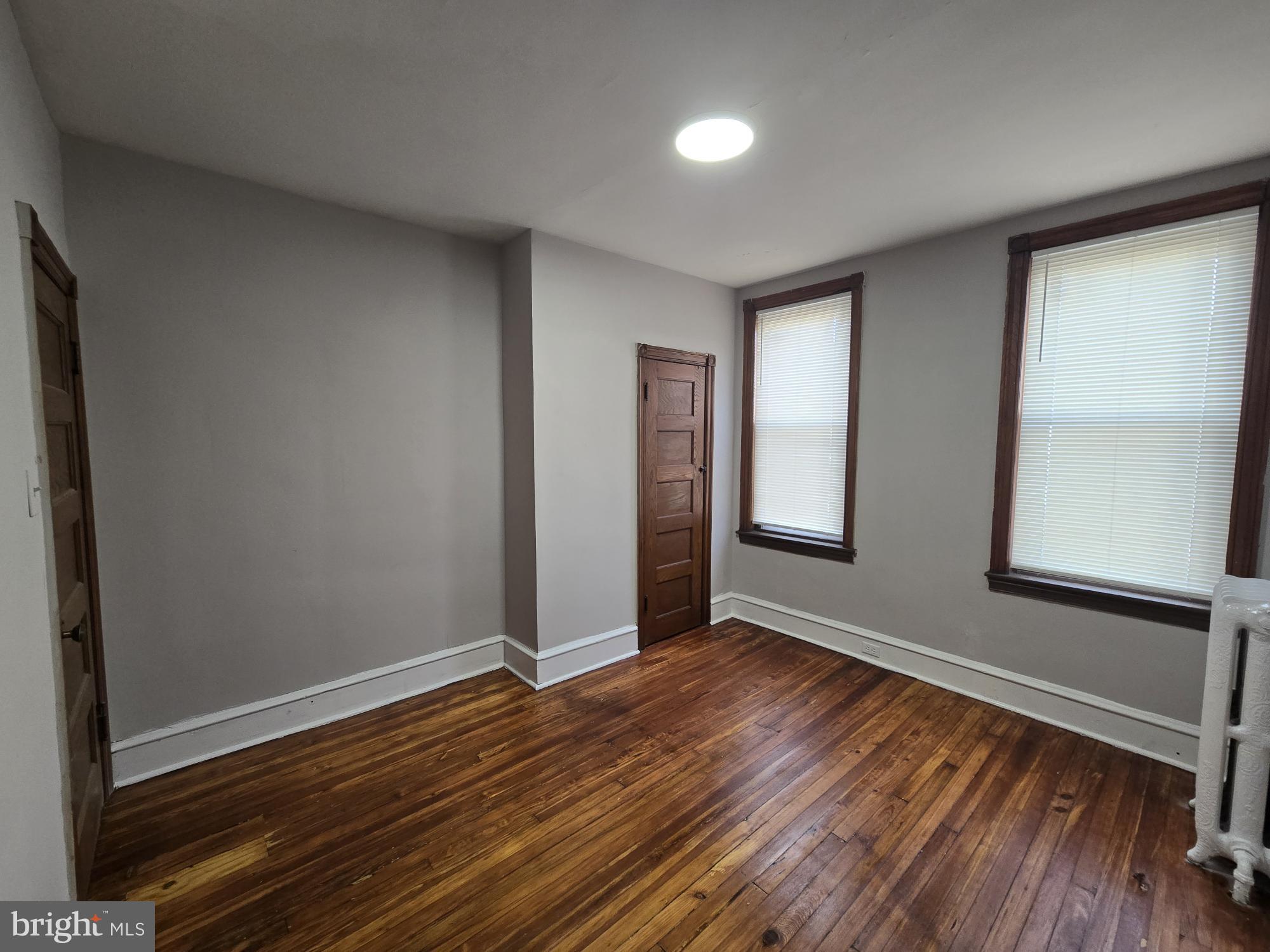 4254 North 7th Street Philadelphia, PA 19140 - Photo 19 of 26 a view of an empty room with wooden floor and a window