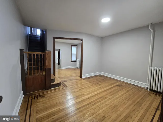 an empty room with wooden floor and entryway