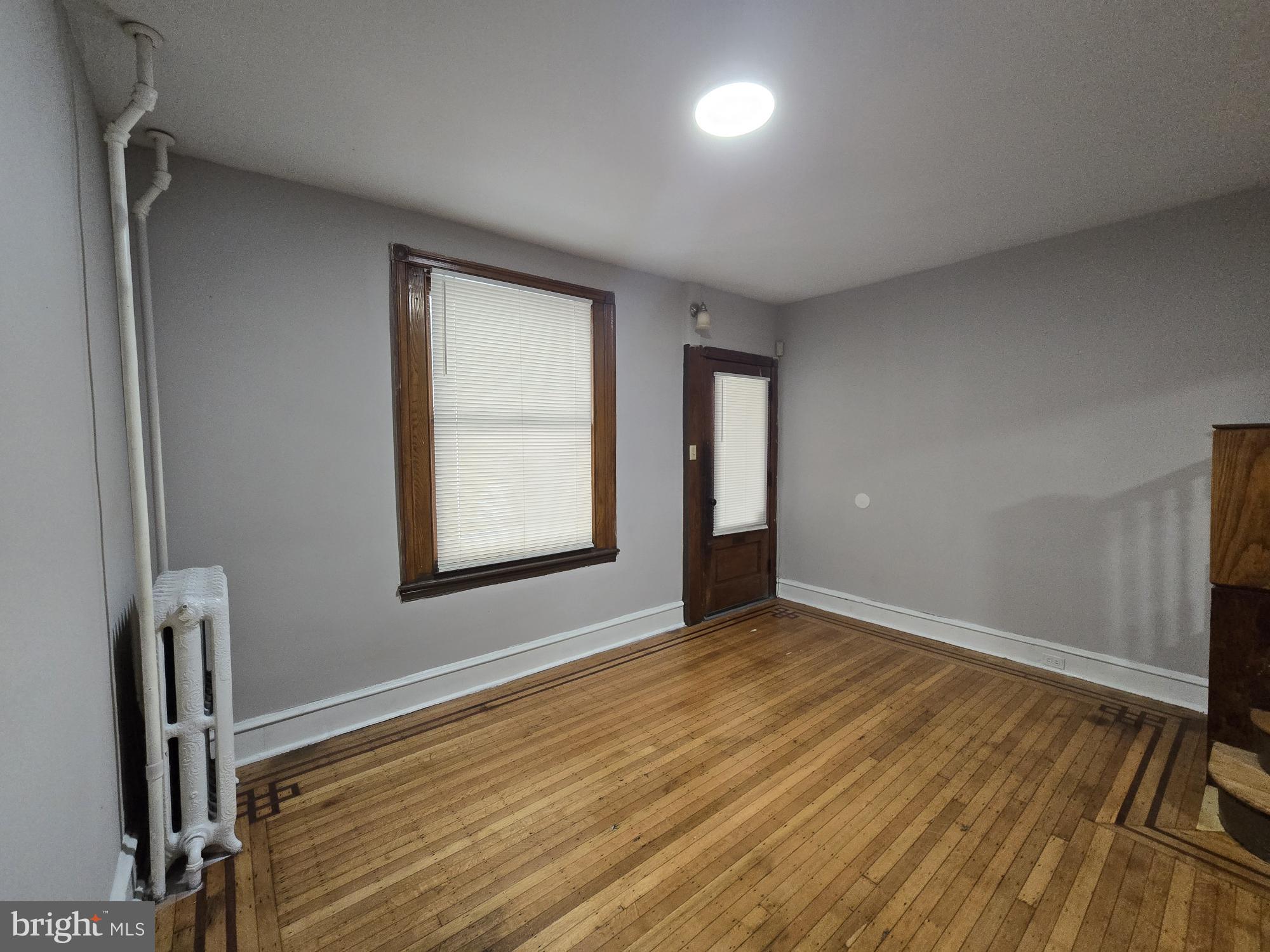 4254 North 7th Street Philadelphia, PA 19140 - Photo 7 of 26 a view of an empty room with window and wooden floor