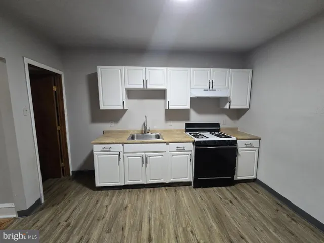 a kitchen with granite countertop a sink stove and refrigerator