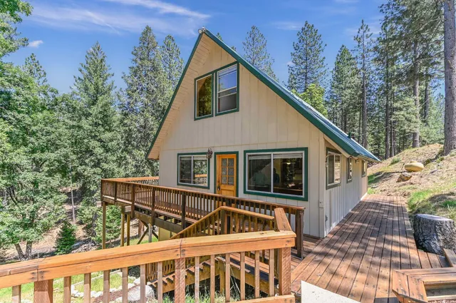 a view of a small house with roof and wooden fence