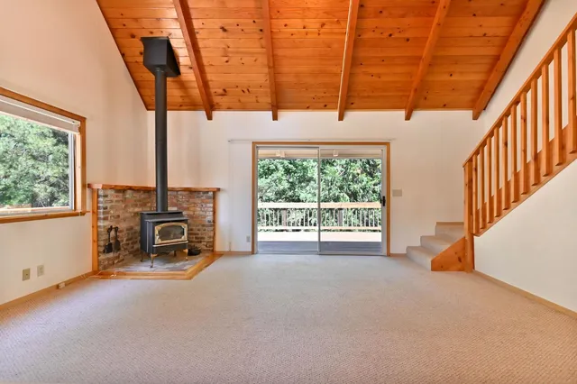 a view of an empty room with a fireplace and a window
